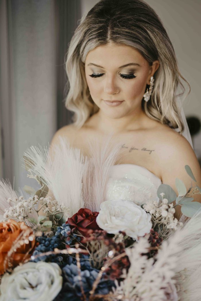Bride holding bouquet in front of sunlit window at beachside wedding in Destin, Florida