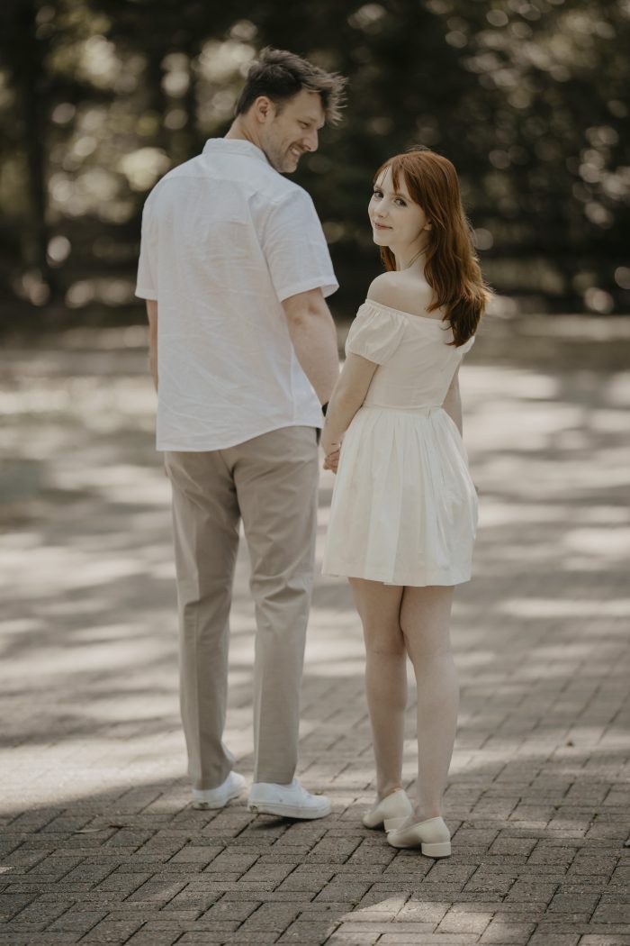 Derek and Emma holding hands during their engagement session at Eden Gardens State Park in Santa Rosa Beach, Florida.