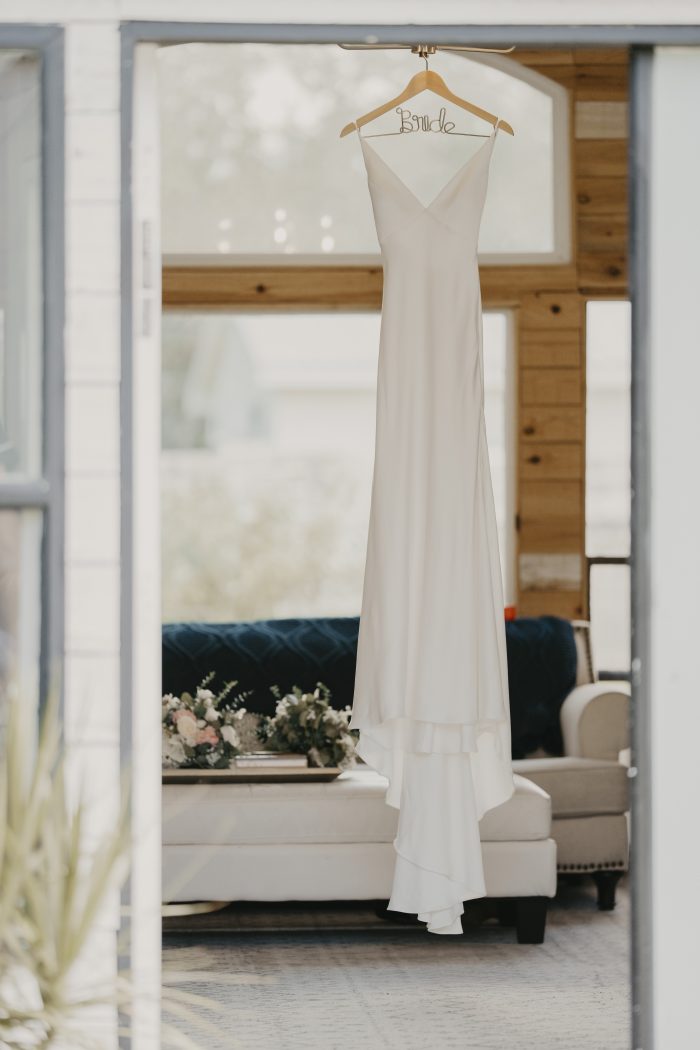 Bride's wedding dress hanging in the bridal suite at Honey Acres Ranch in DeLand, Florida before Ariya and Jorge's wedding ceremony.
